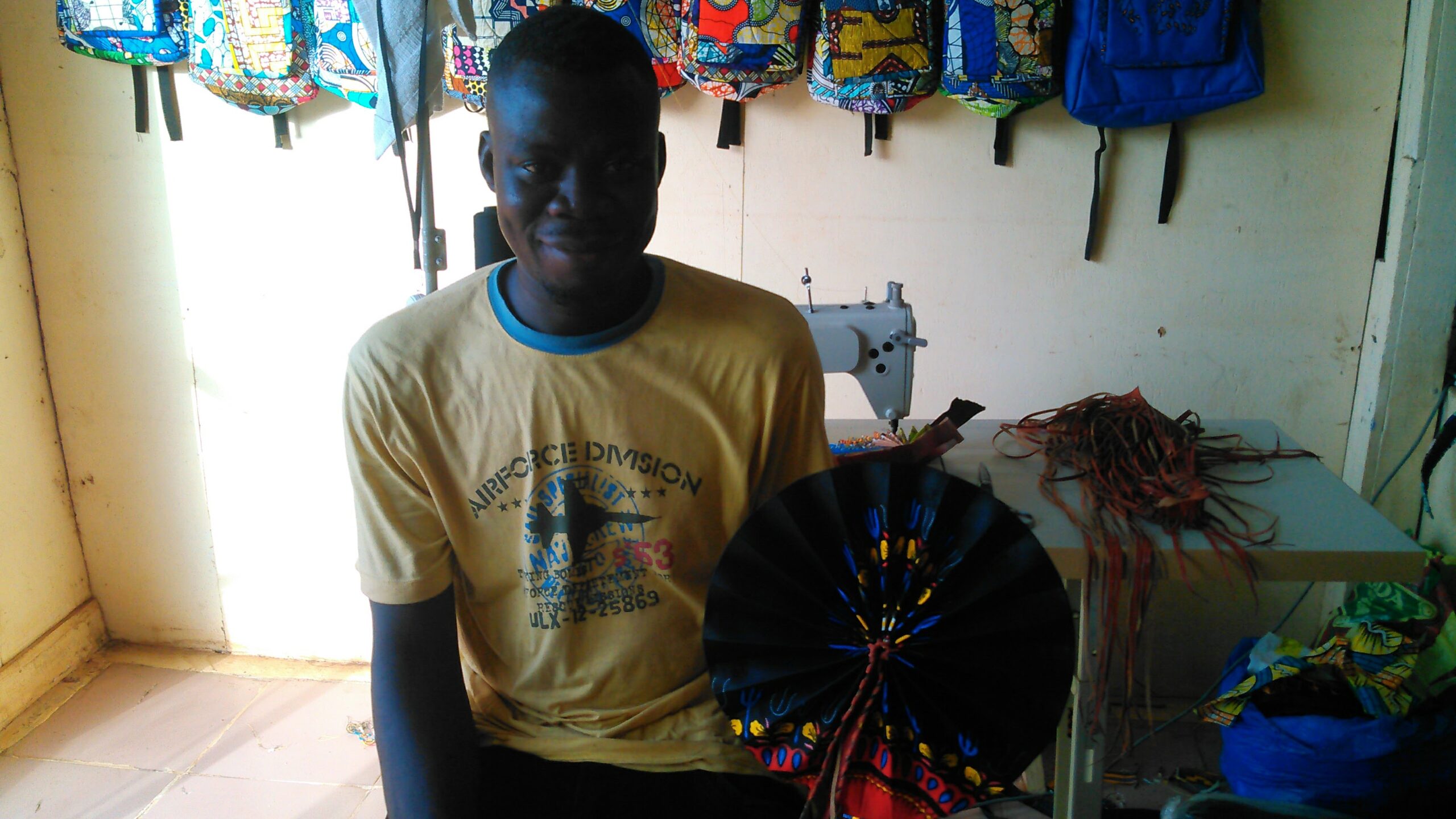 Ghana leather craftsman showcasing hand-made leather fans for artisan social enterprise program.