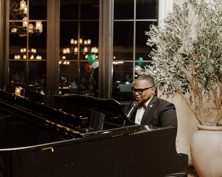 Live pianist performing at a Global Ties Akron community event, highlighting the meaning of global ties through cultural exchange and local arts.