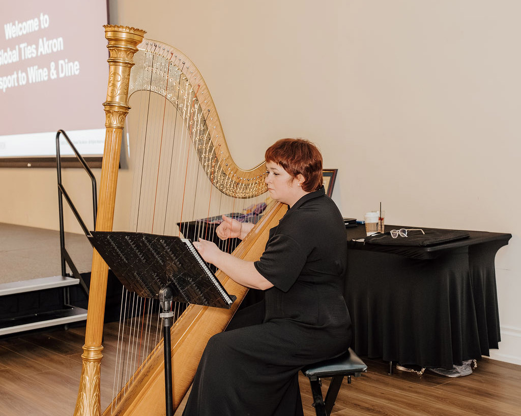 Harpist performing at a Global Ties Akron reception, creating a welcoming atmosphere that reflects the meaning of global ties and strengthens community connections.
