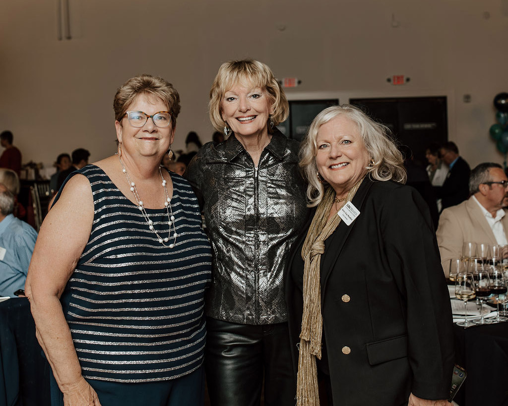 Smiling volunteers at nonprofit fundraiser showcasing benefits of sponsoring a local nonprofit.
